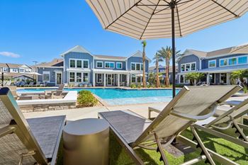 Resort style pool with sun loungers and umbrella